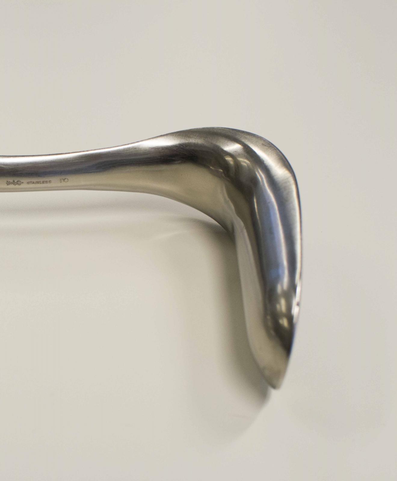 Instrumento con forma de "C", realizado en una lámina metálica curva