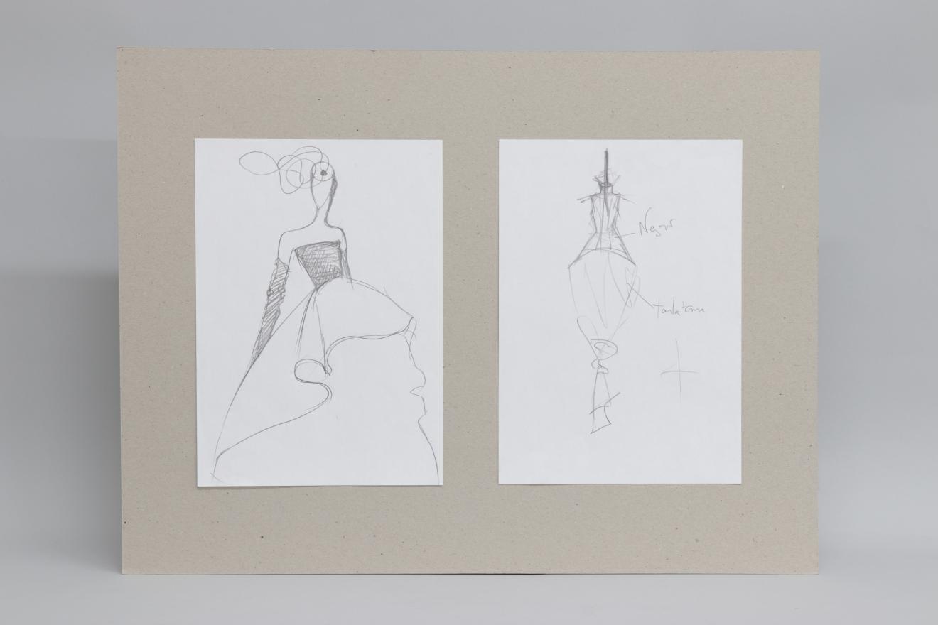 Dos dibujos sobre cartón gris. El primero, un esbozo de figurín sobre fondo blanco y el segundo, un esquema básico de vestido con anotaciones