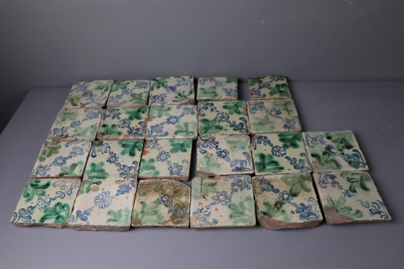 Paño compuesto por veintidós olambrillas esmaltadas en blanco con decoración vegetal azul y verde