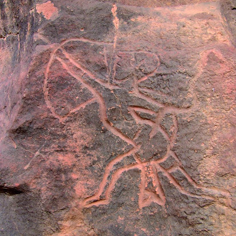 Fotografía de formato cuadrado. Muestra un detalle de piedra rojiza sobre el que se ha representado un arquero en el momento de mayor tensión, lanzando una flecha